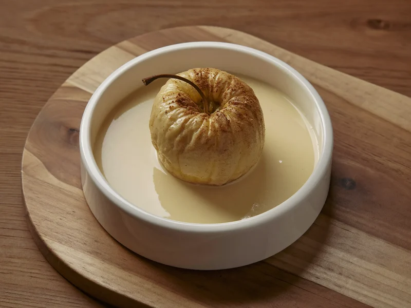 Gebackener Apfel mit Zimt und Vanillesauce in kleiner weißer Schale